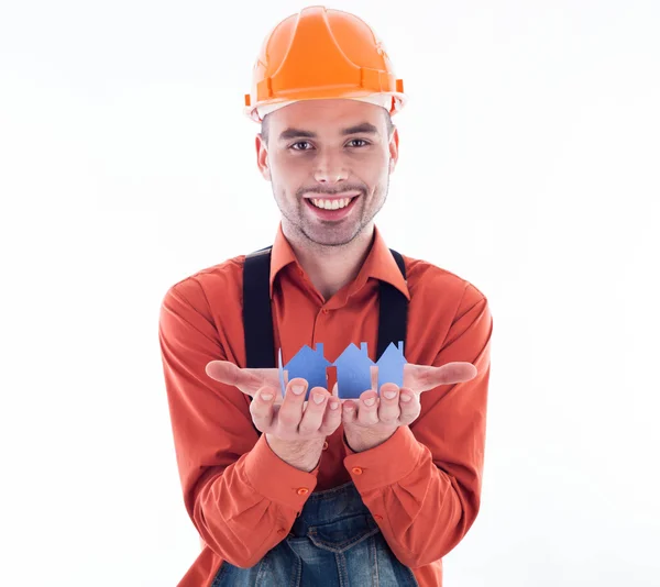 Um construtor segurando casas de papel . — Fotografia de Stock