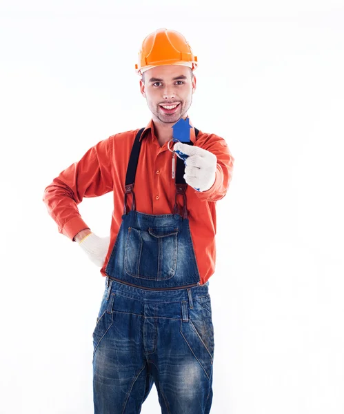 Een man van de bouwer holding een sleutel en een papier-huis. — Stockfoto