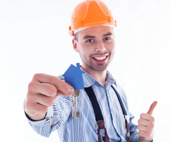 A builder man holding a key and a paper house. Stock Photo