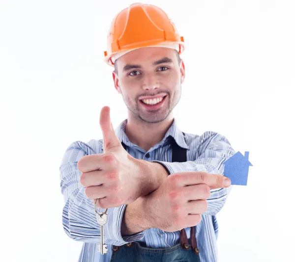 A builder man holding a key and a paper house. Stock Picture