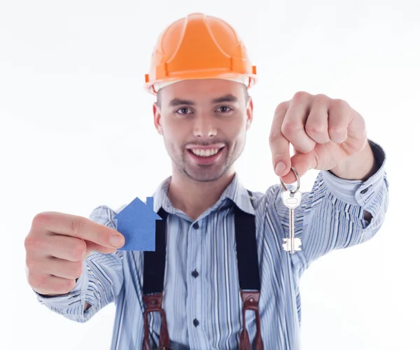 A builder man holding a key and a paper house. Royalty Free Stock Images