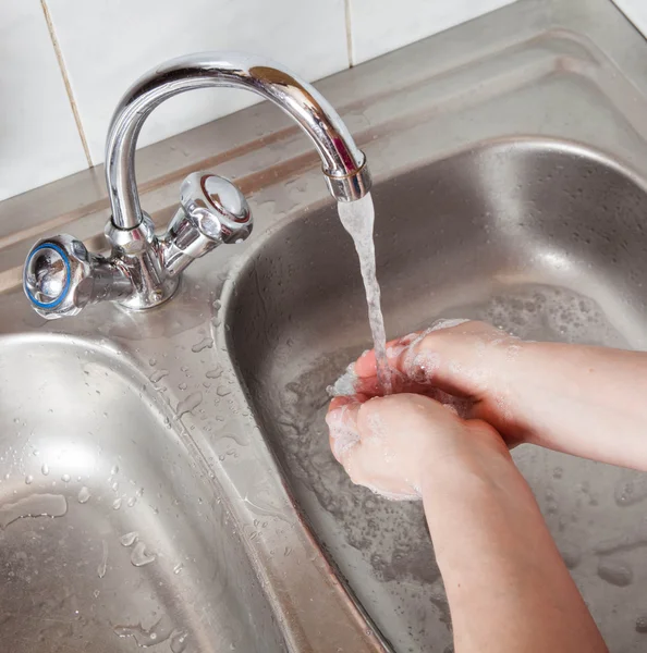 Женские руки в мыле под проточной водой — стоковое фото