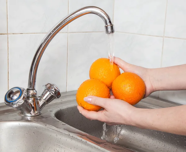 Wash fruits under running water — Stock Photo, Image