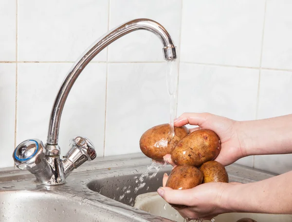 Wash vegetables under running water — Stock Photo, Image