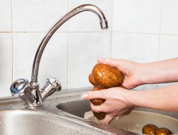 Wash vegetables under running water — Stock Photo, Image