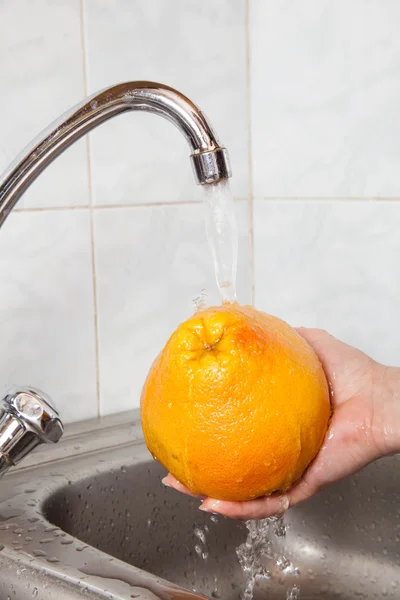 Wash fruits under running water — Stock Photo, Image