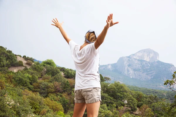 Joven mujer feliz de pie sobre una roca — Foto de Stock