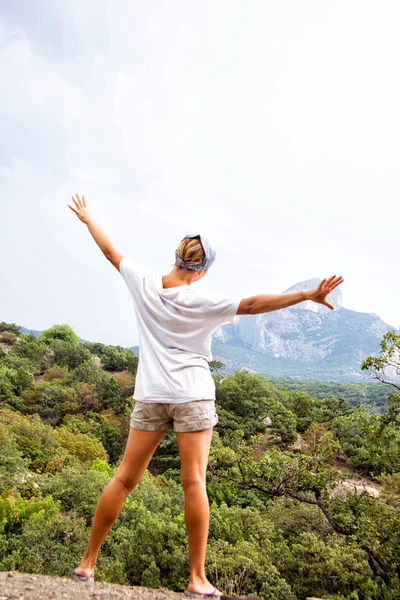 Joven mujer feliz de pie sobre una roca —  Fotos de Stock