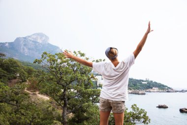 kayanın üzerinde duran genç mutlu kadın