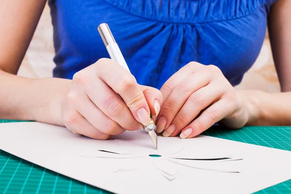 Mão feminina cortando flor de papel — Fotografia de Stock