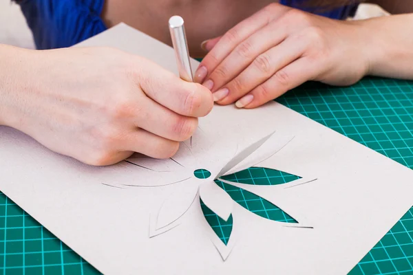 Woman's hand cutting out flower — Stock Photo, Image