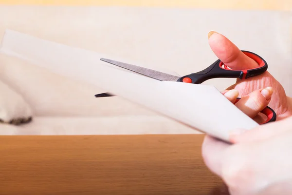 Woman's hand cutting paper — Stock Photo, Image