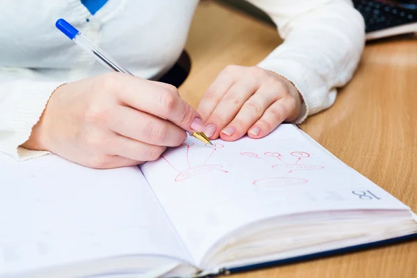 Geschäftsfrau schreibt mit Stift in Notizblock — Stockfoto