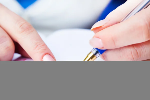 Geschäftsfrau schreibt mit Stift in Notizblock — Stockfoto