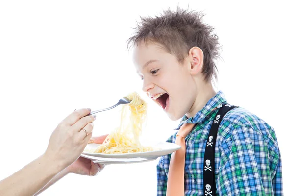 Menino está comendo espaguete usando garfo — Fotografia de Stock