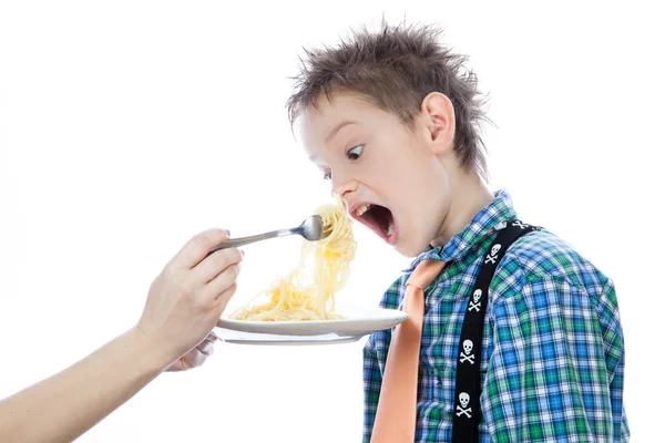Menino está comendo espaguete usando garfo — Fotografia de Stock