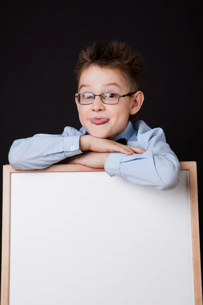 Porträt eines fröhlichen Jungen, der auf ein weißes Banner zeigt — Stockfoto