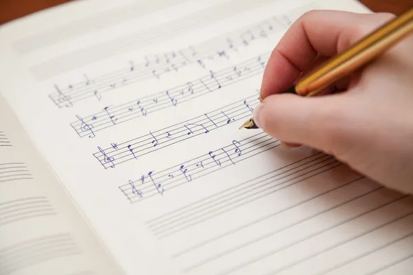 Χέρι με στυλό και μουσική φύλλο — Φωτογραφία Αρχείου