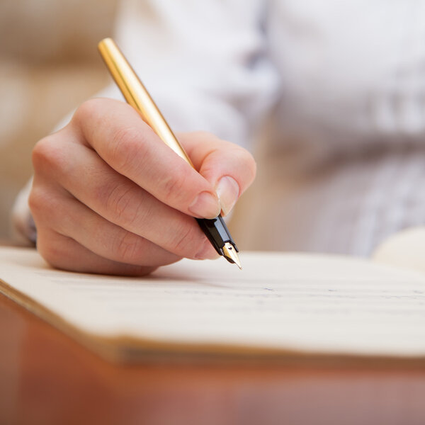 Hand with pen and music sheet