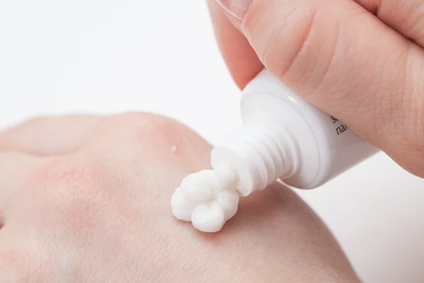 Putting cream on hand — Stock Photo, Image