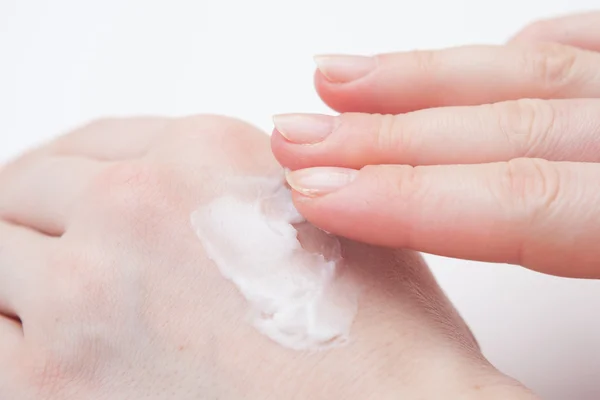 Putting cream on hand — Stock Photo, Image