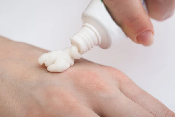 Putting cream on hand — Stock Photo, Image