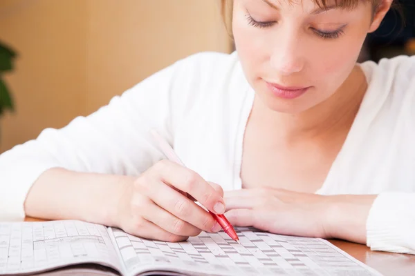 Vrouw doen kruiswoordraadsels — Stockfoto