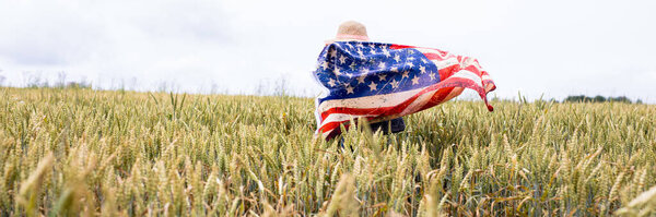 Little cute girl with american flag on the field