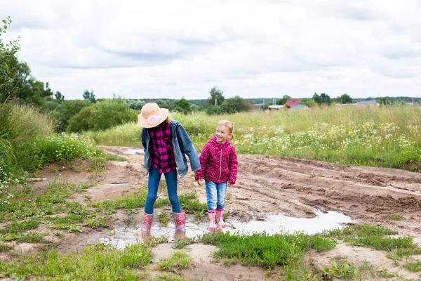 Two Smiling Girls Run Puddles Play — Stockfoto