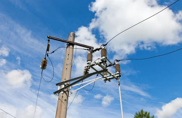 Poste de energia elétrica com fio contra céu azul brilhante e nuvens — Fotografia de Stock