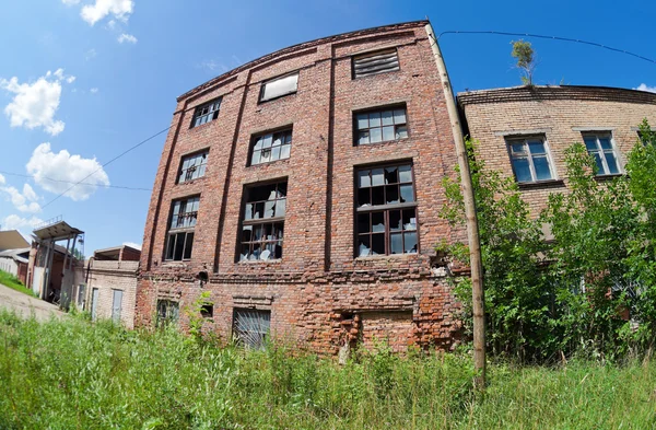 Vecchio edificio abbandonato contro il cielo blu in giorno d'estate . — Foto Stock