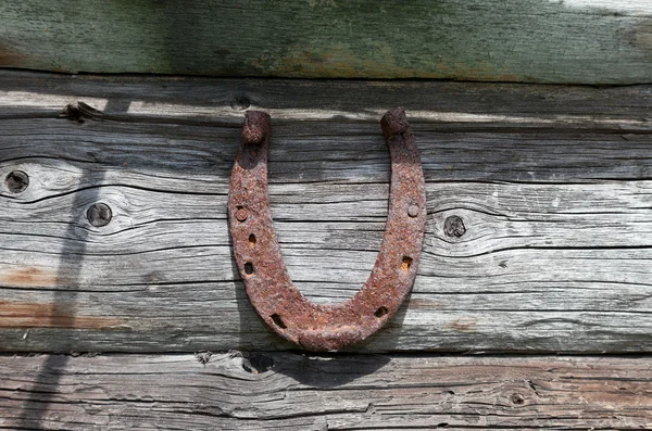 Vintage ferro di cavallo arrugginito inchiodato al vecchio muro di legno — Foto Stock