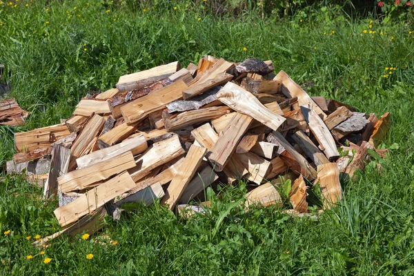 Pile de bois de chauffage haché couché sur l'herbe — Photo