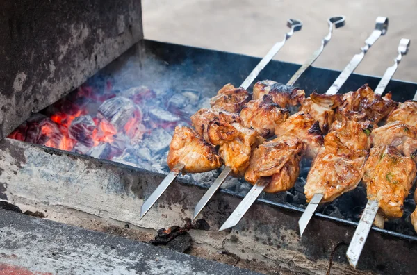 As partes suculentas de carne com o molho preparam-se no fogo (prato de carne shish) — Fotografia de Stock