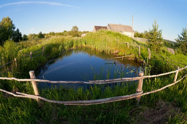 Small pond in the village on the sunset — Stock Photo, Image