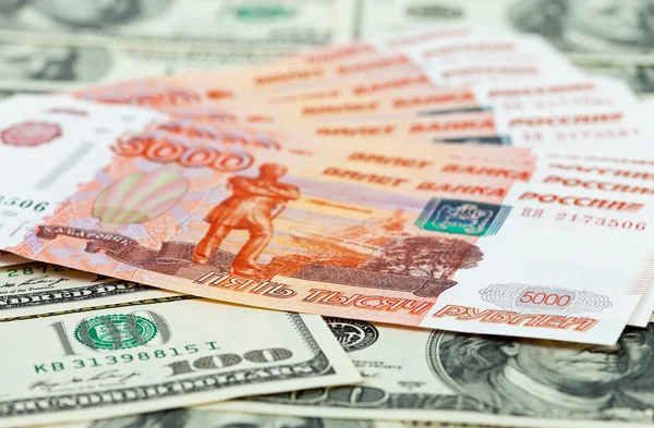 Rublos russos contas que colocam sobre dólares de fundo — Fotografia de Stock