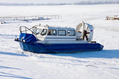 Hovercraft crossing frozen river Volga in Samara, Russia clipart