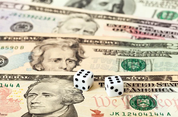 Two dice laying over a pile U.S. dollars — Stock Photo, Image