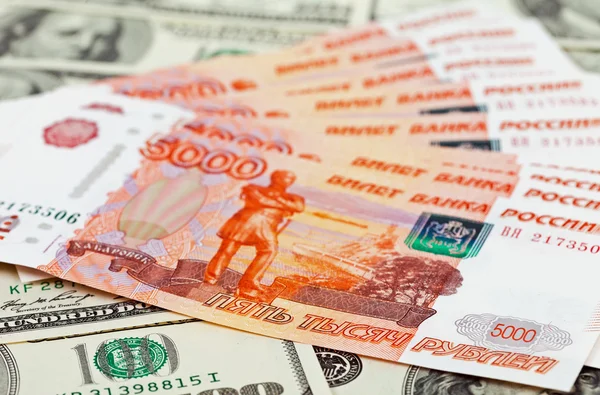 Russian roubles bills laying over dollars background — Stock Photo, Image