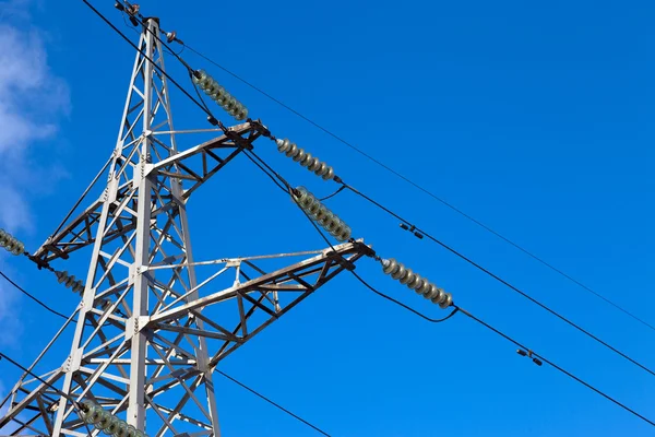 Yüksek gerilim elektrik pilon üzerinde mavi gökyüzü — Stok fotoğraf