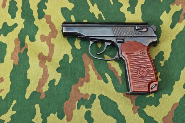 Handfeuerwaffe auf getarntem Hintergrund — Stockfoto