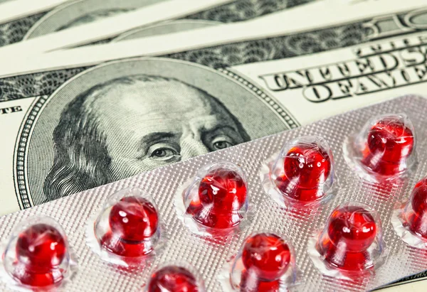 Pills over money background — Zdjęcie stockowe