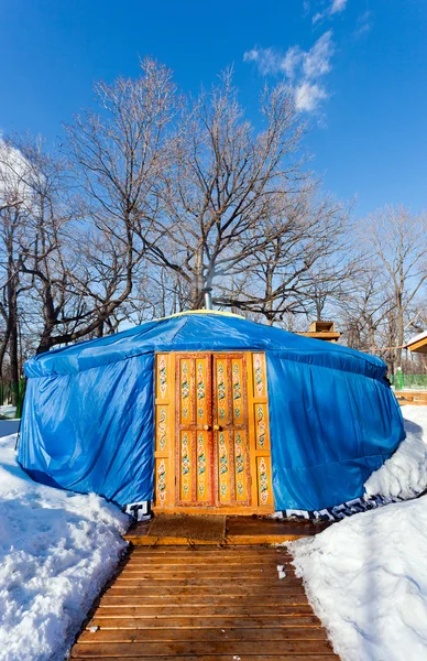 Een blauwe yurt met grote gesloten ingerichte oranje deur in de wint — Stockfoto