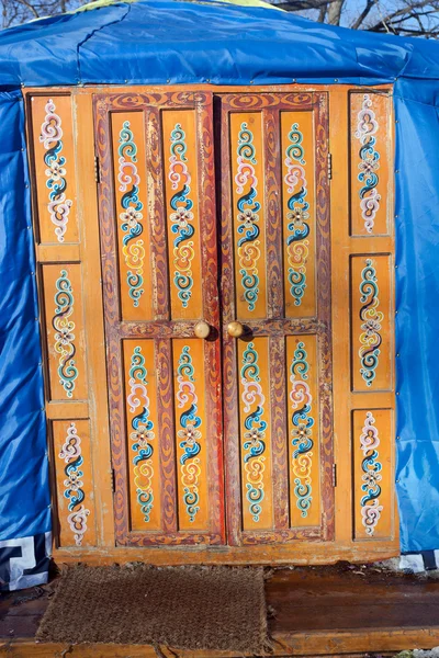 Wooden decorated orange door in kazakh yurt — Stock Photo, Image