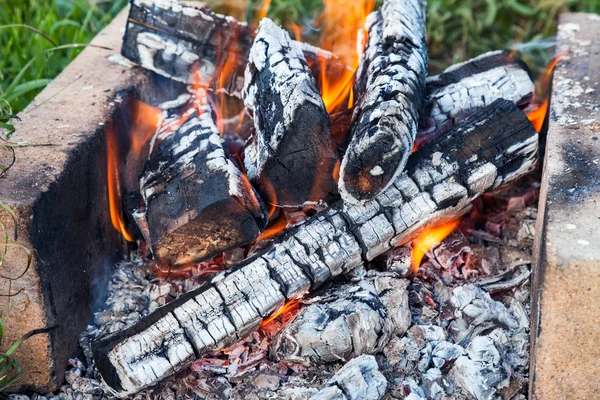 Fechar-se de um fogo quente que queima em uma fogueira — Fotografia de Stock