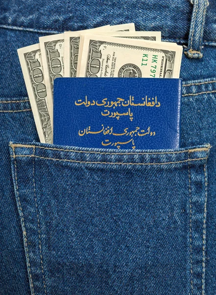 バックのジーンズのポケットの中のアフガニスタン パスポートおよびドル手形 — ストック写真