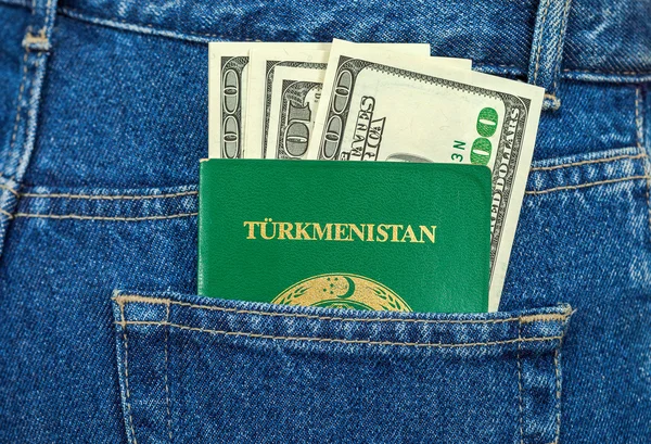 Turkmenistan passport and dollar bills in the back jeans pocket — Stock Photo, Image