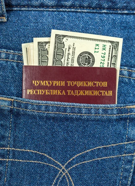 Passaporte do Tajiquistão e notas de dólar no bolso das calças de ganga — Fotografia de Stock