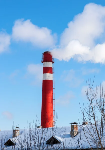 Röd fabrik skorstenen mot blå himmel på vintern — Stockfoto