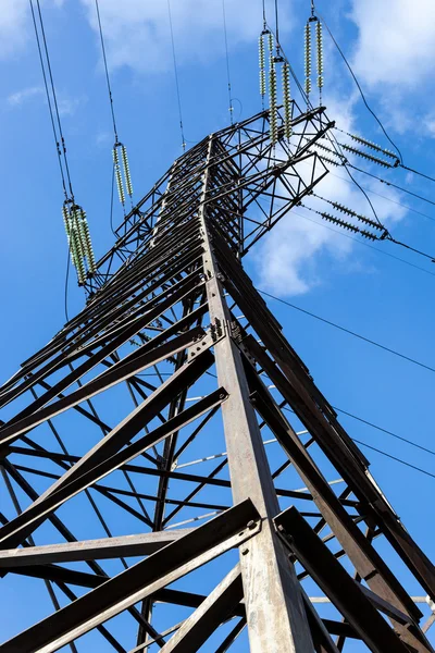 Vysoké napětí elektřiny pylonu proti modré obloze — Stock fotografie